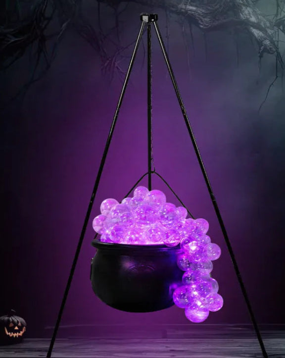 Hanging black cauldron with purple LED lights against a dark background
