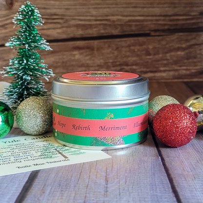 Candle tin with festive label surrounded by Christmas decorations on a wooden surface