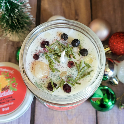 Decorative candle in a jar with herbs and spices on a wooden surface with Christmas decorations.