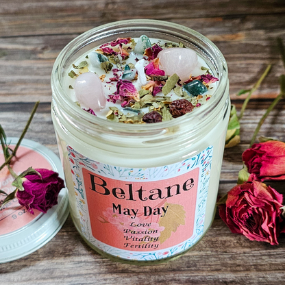 Jar of Beltane May Day candle with decorative elements on a wooden surface