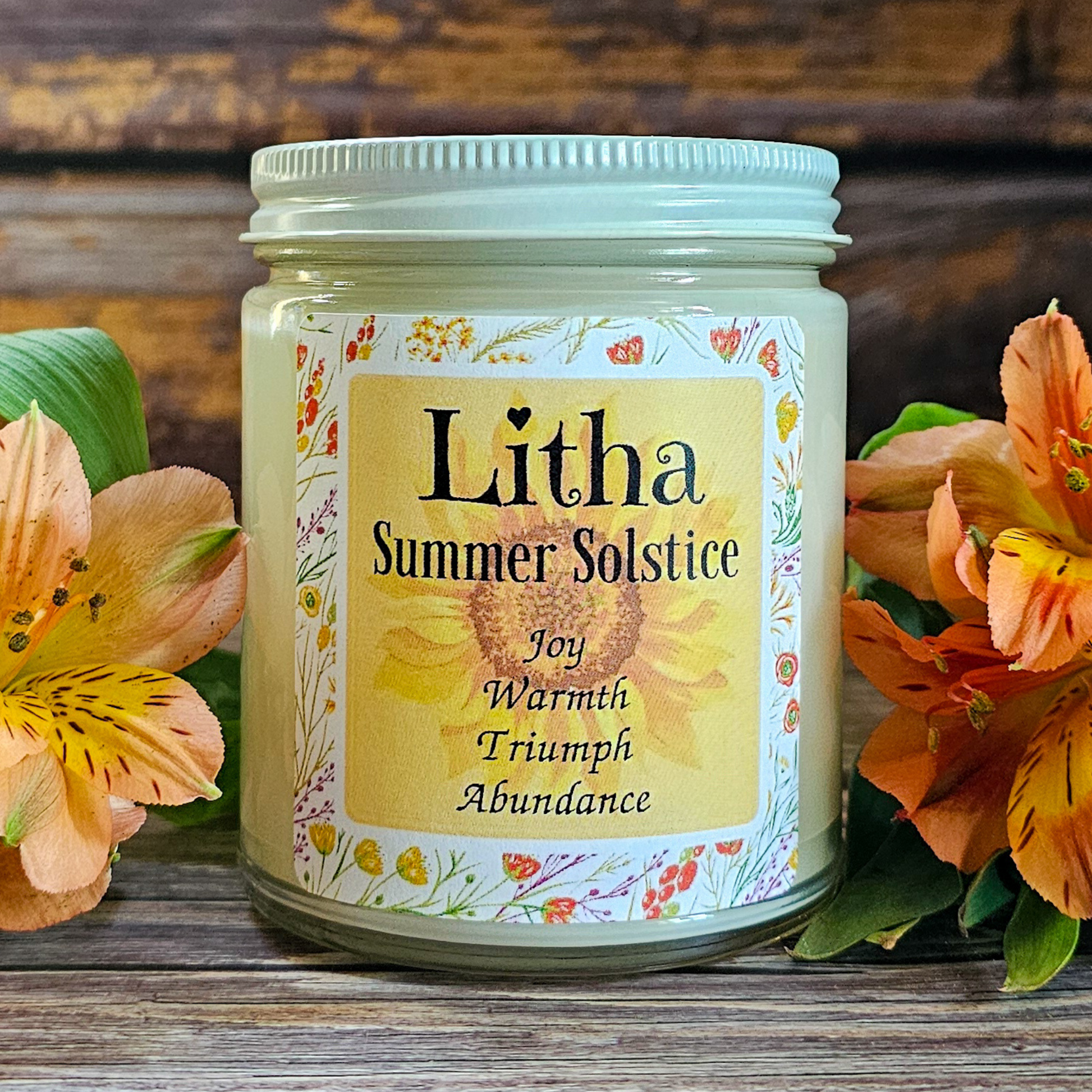 Candle jar labeled 'Litha Summer Solstice' with floral design on a wooden surface.