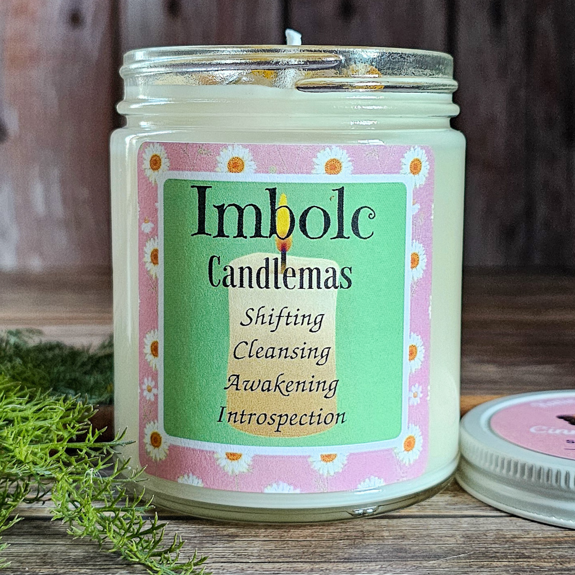 Candle with 'Imbolc Candlemas' label on a wooden surface