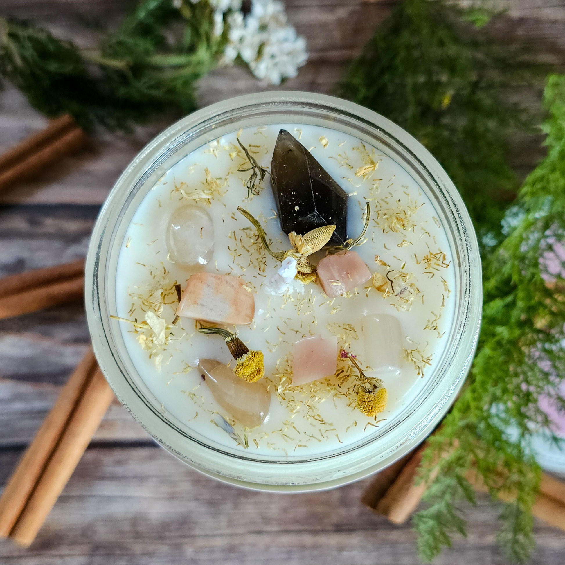 Jar with decorative elements on a wooden surface with cinnamon sticks and greenery.