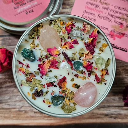Candle with stones and dried flowers on a wooden surface