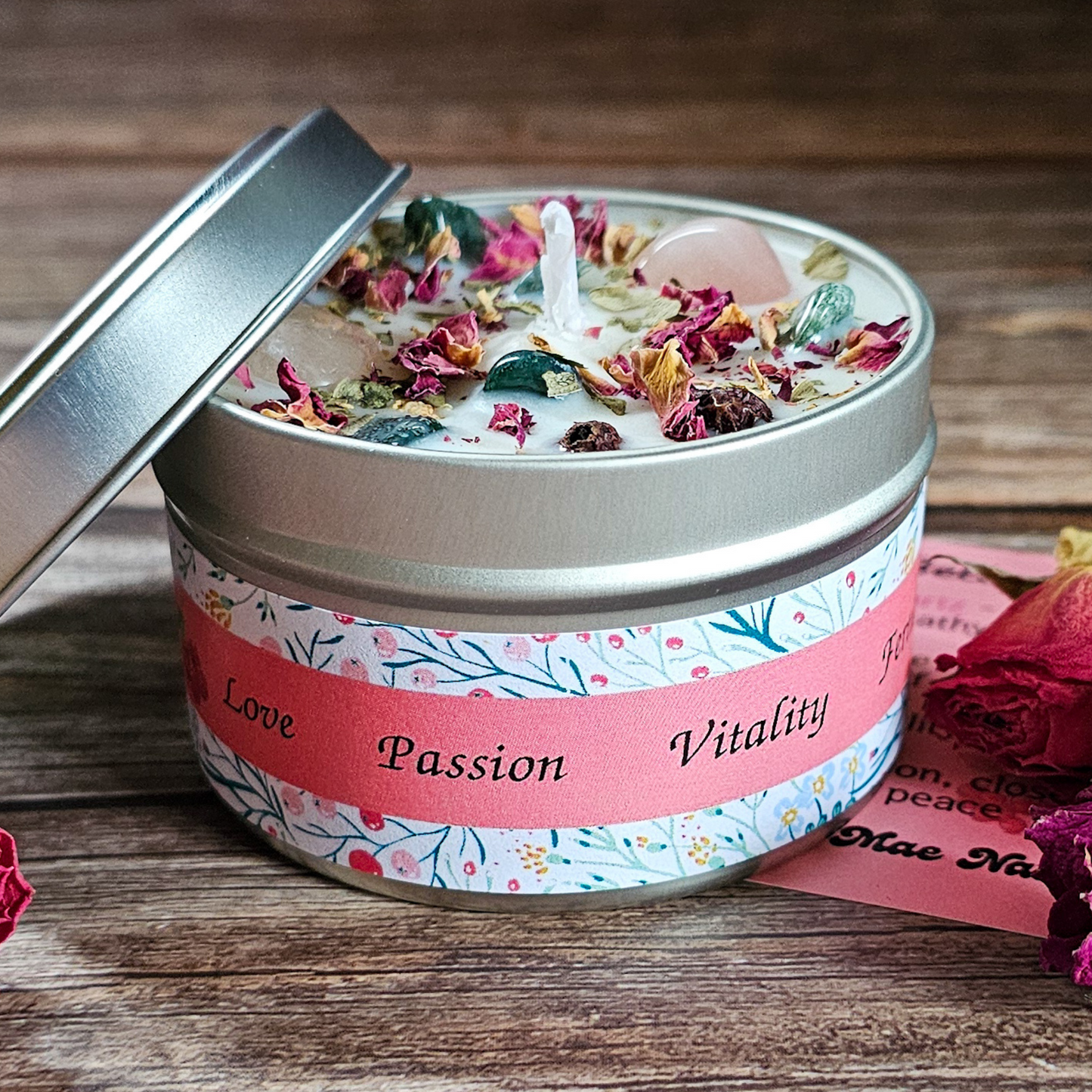 Candle in a tin with decorative label on a wooden surface