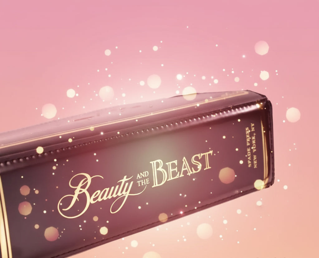 Black handbag with 'Beauty and the Beast' gold text on a white background