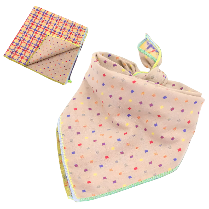 Beige fabric with colorful square pattern and folded book on a white background