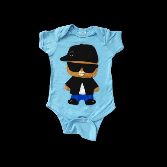 Blue baby onesie with a cartoon character wearing sunglasses and a cap on a white background