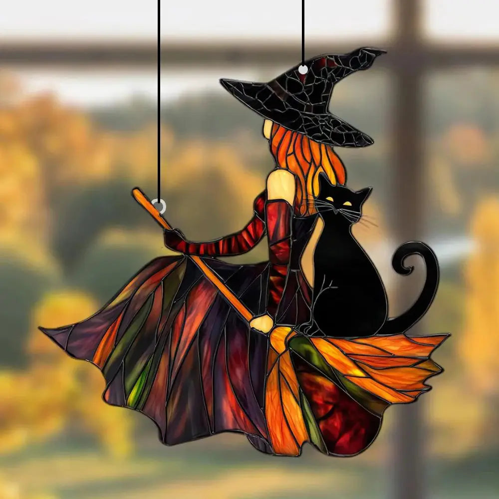 Decorative stained glass witch and black cat on a broom with autumn leaves.