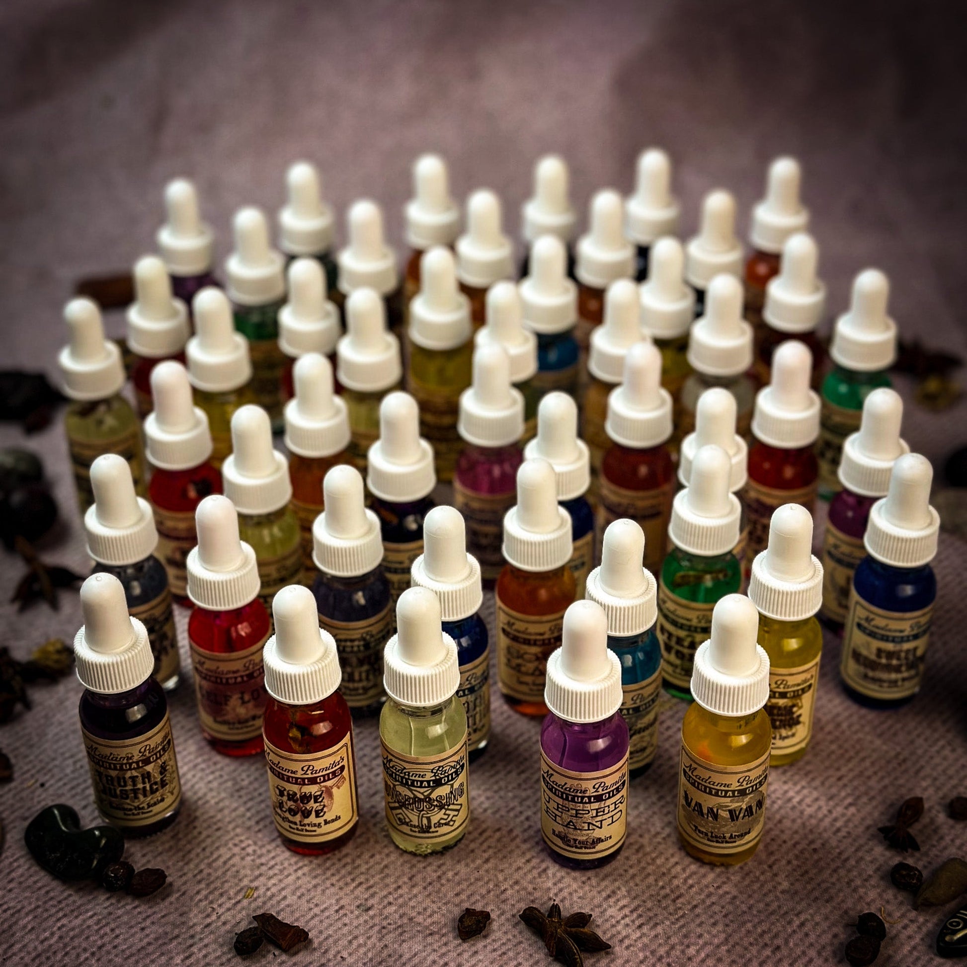 Collection of small dropper bottles with various colored liquids on a textured surface.