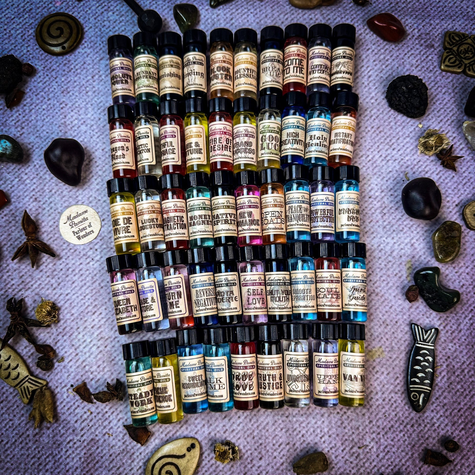 Collection of small bottles with labels on a textured surface with natural elements.