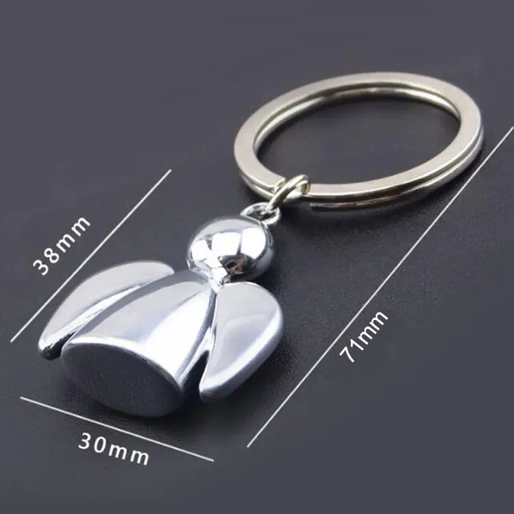 Silver bell-shaped keychain with measurements on a black background