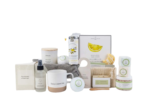 Collection of home care products including a mug, candles, and boxes on a white background