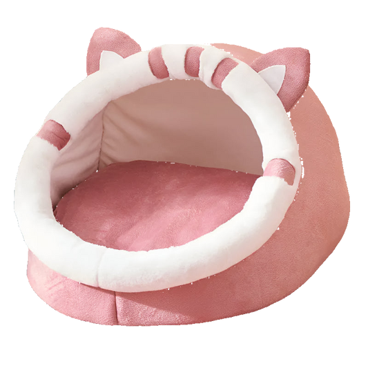Pink pet bed with cat ears on a patterned surface