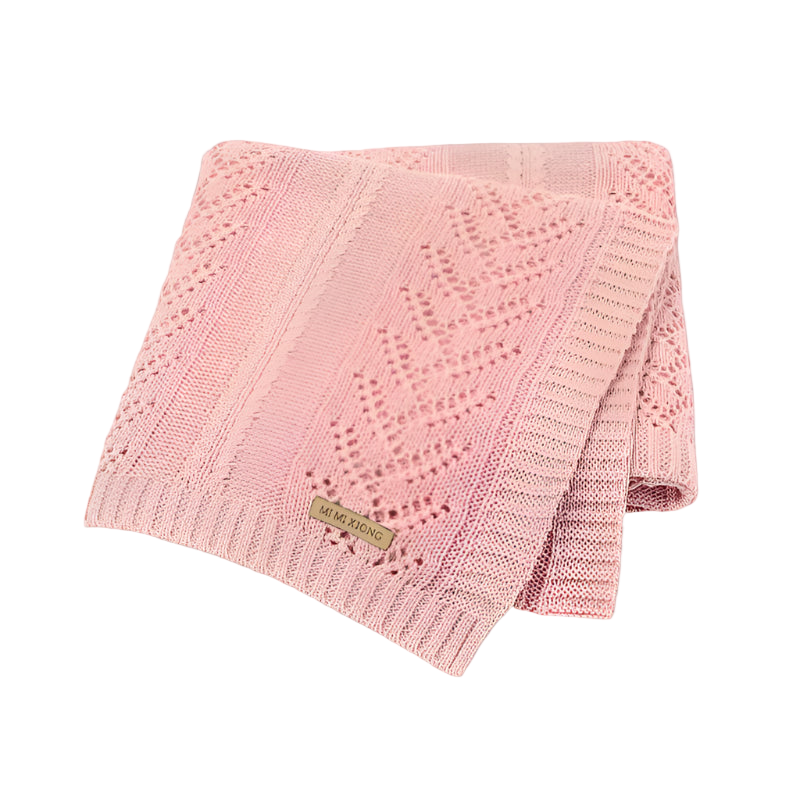 Pink knitted blanket with a brand label on a white background