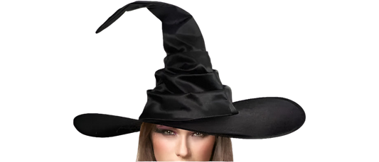 Woman wearing a black witch hat holding a carved pumpkin on a white background