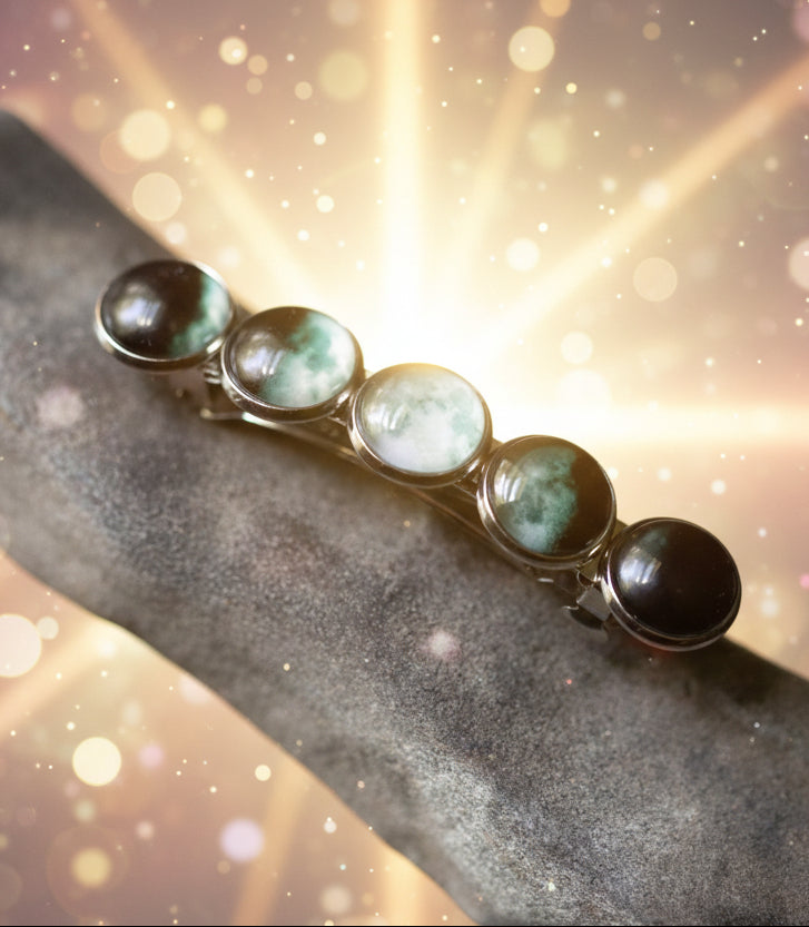 Bracelet with green and black gemstones on a stone surface