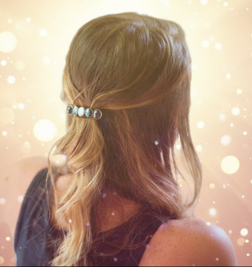 Person with a decorative hair accessory in their hair against a neutral background