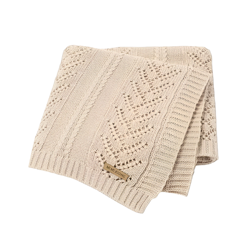 Beige knitted blanket with a subtle pattern on a white background