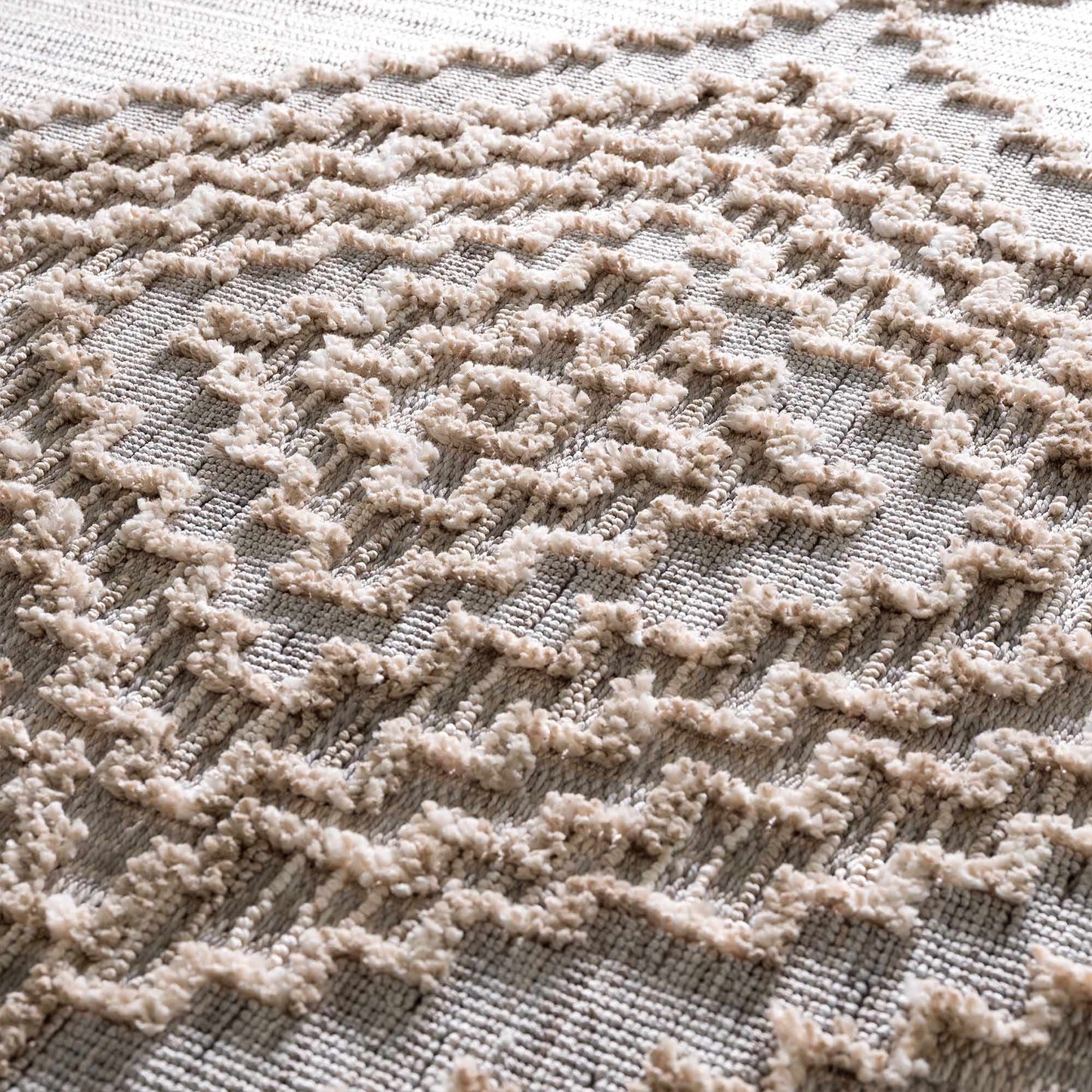 Close-up of a textured beige rug with a geometric pattern