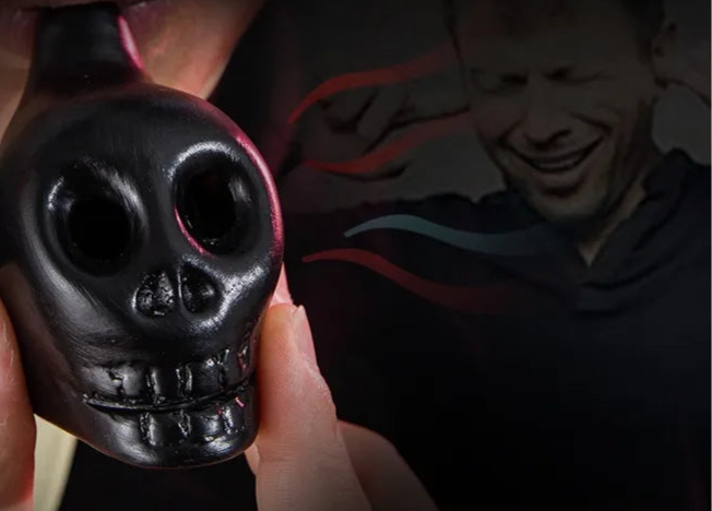 Black skull-shaped decoration held by a hand with Halloween-themed text above.