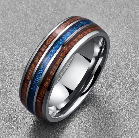 Silver ring with wooden and blue inlay on a gray background