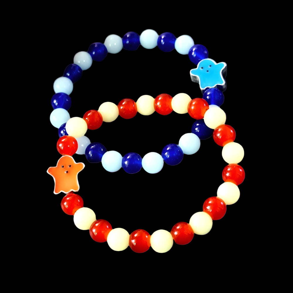 Two beaded bracelets with colorful charms on a dark surface