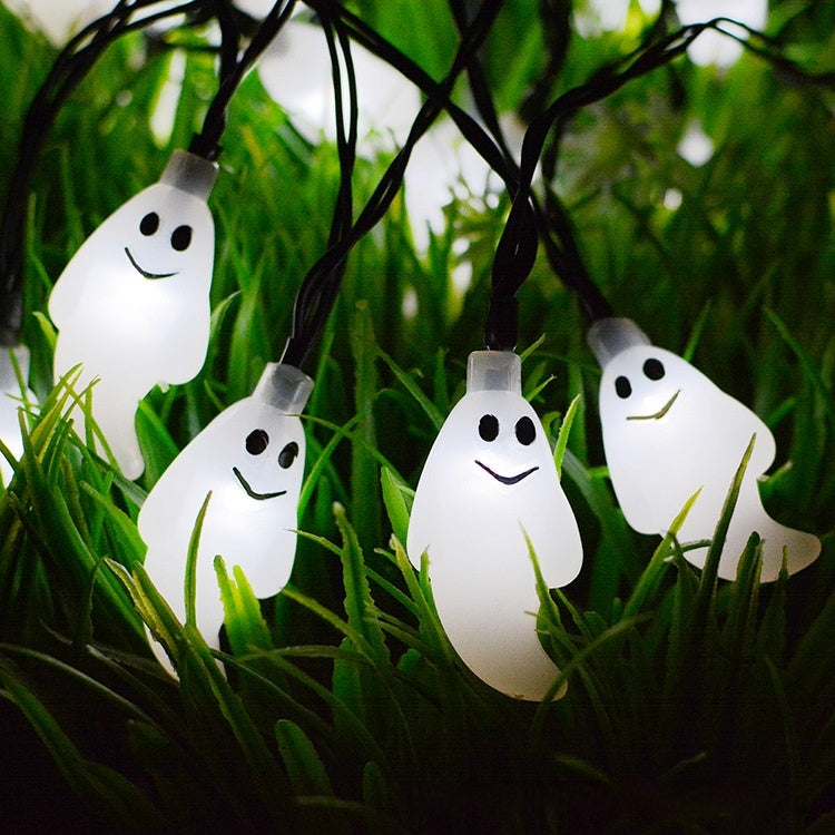 String of ghost-shaped lights on a grassy background