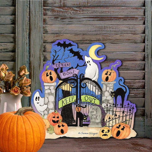 Halloween-themed decorative sign with pumpkins, ghosts, and a gate on a wooden background.