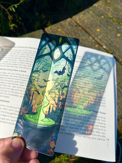 Decorative bookmark with a fantasy design held over an open book.