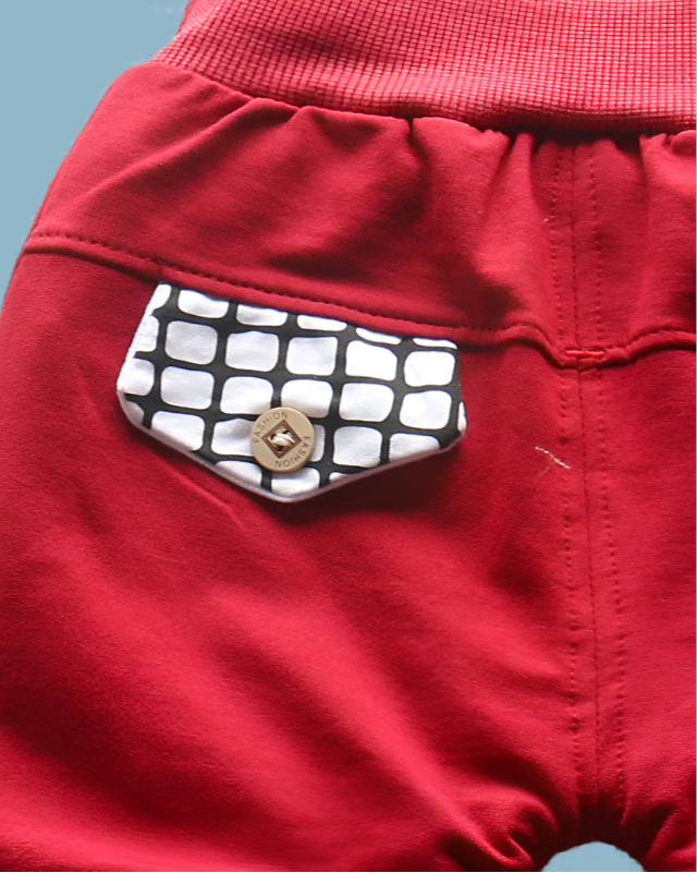 Red pants with a black and white checkered pocket on a woven surface