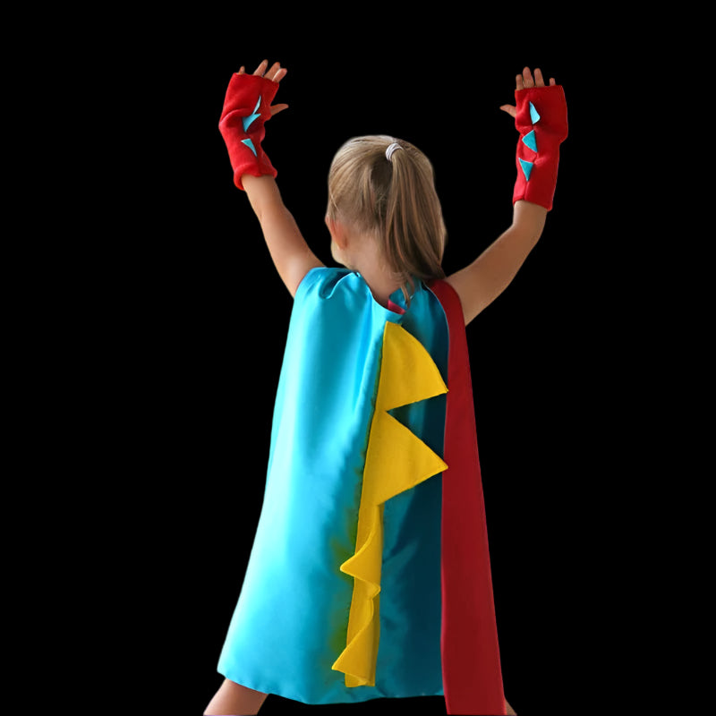 Child wearing a colorful superhero cape and gloves outdoors.