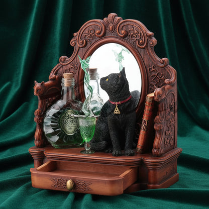 A decorative gothic-style wooden cabinet or shelf with an ornate carved frame, a small drawer at the bottom, a black cat figurine, two glass bottles, and a green goblet on a white background.
