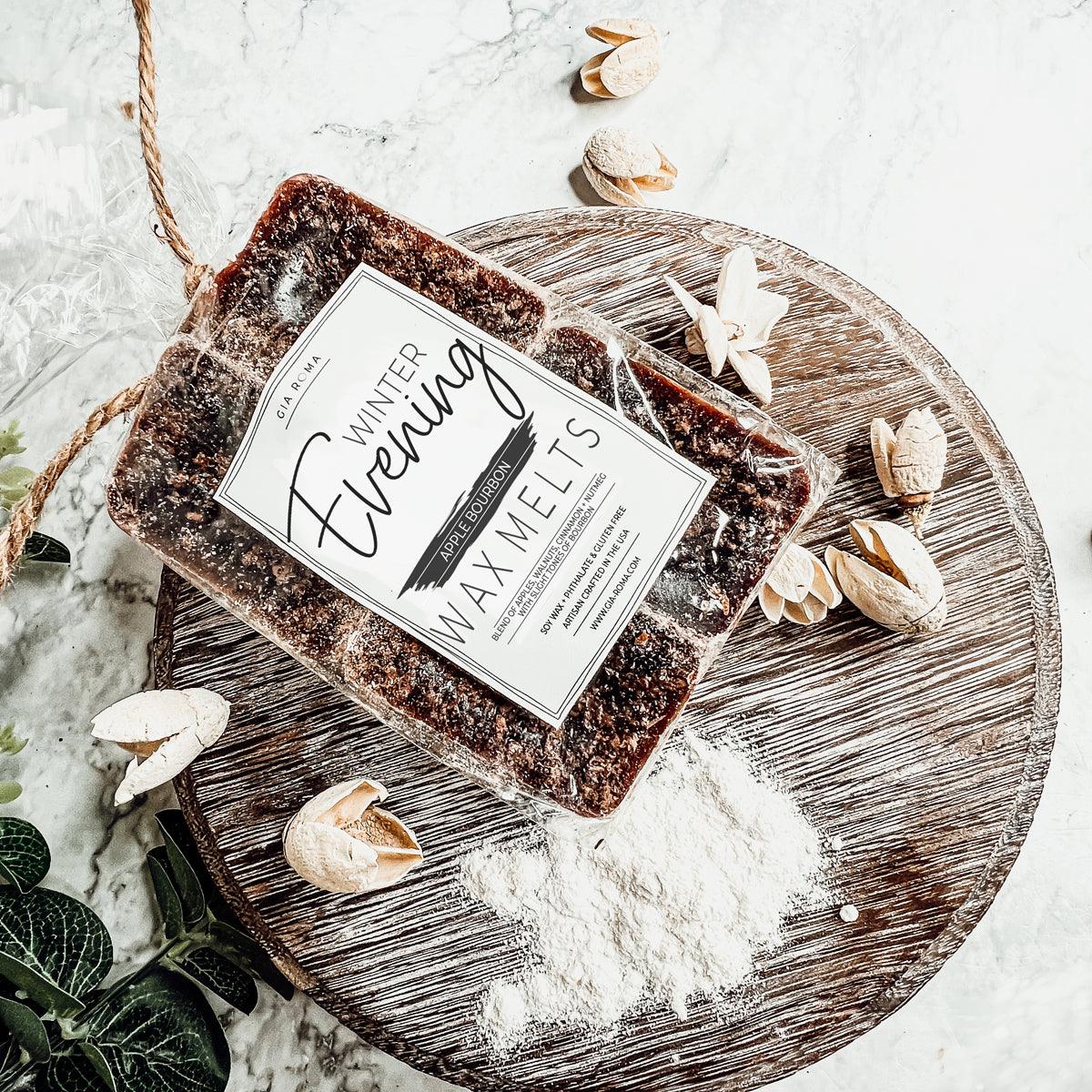 Block of wax melts labeled 'Winter Evening' on a wooden board with decorative elements.