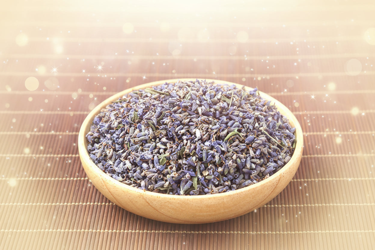 Wooden bowl filled with dried lavender flowers on a bamboo mat.