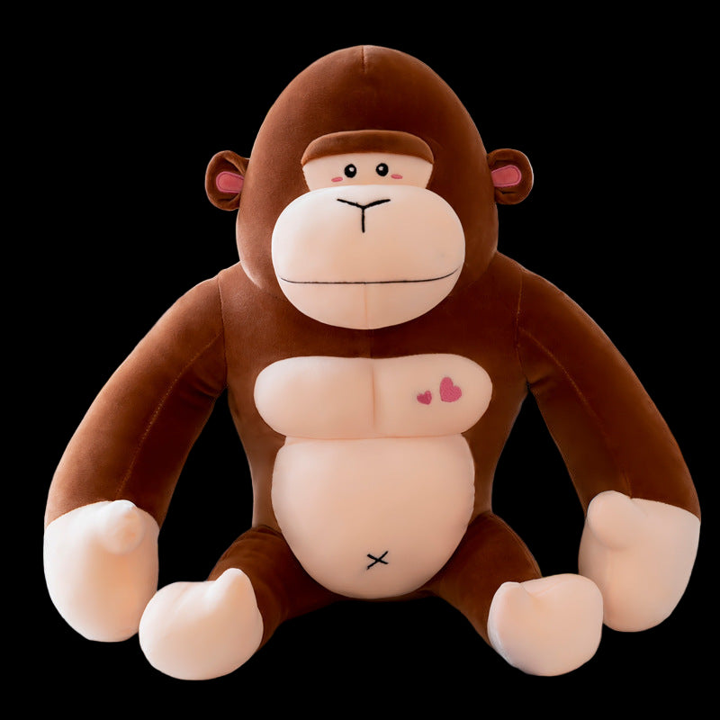 Plush monkey toy with pink cheeks and heart on belly sitting on a surface.