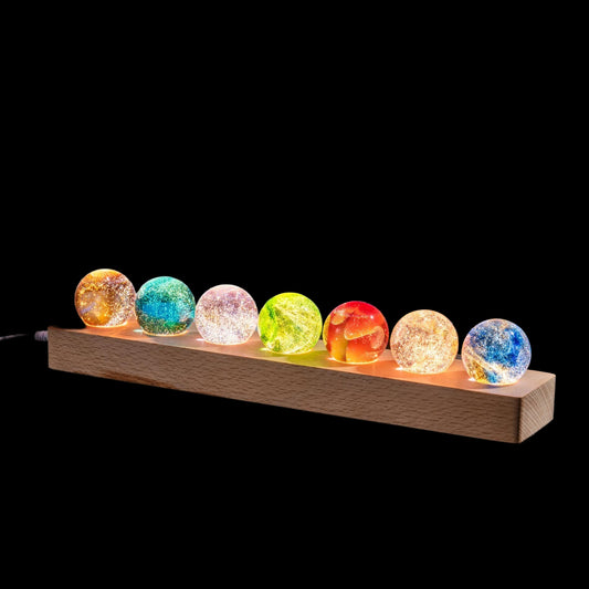 Colorful crystal balls on a wooden stand against a night sky with stars.
