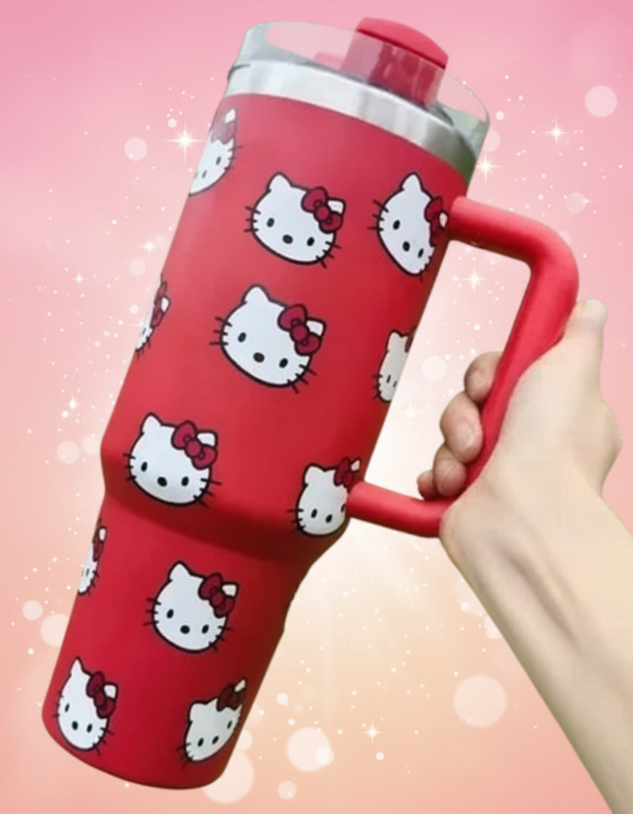 Red tumbler with Hello Kitty pattern held by a hand against a blurred green background