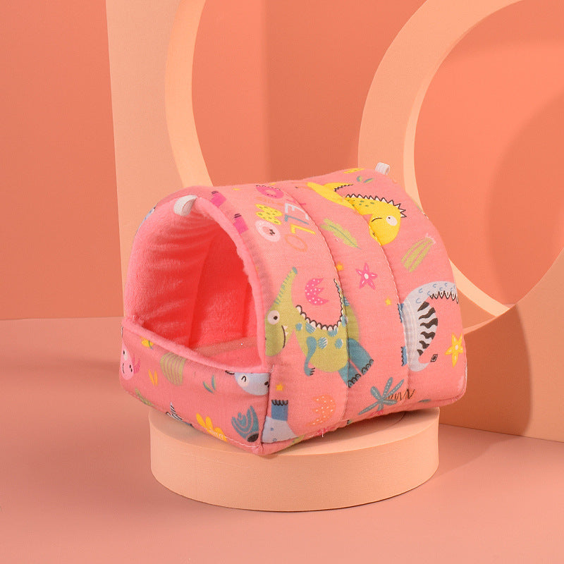 Pink pet bed with cartoon animal pattern on a peach-colored background