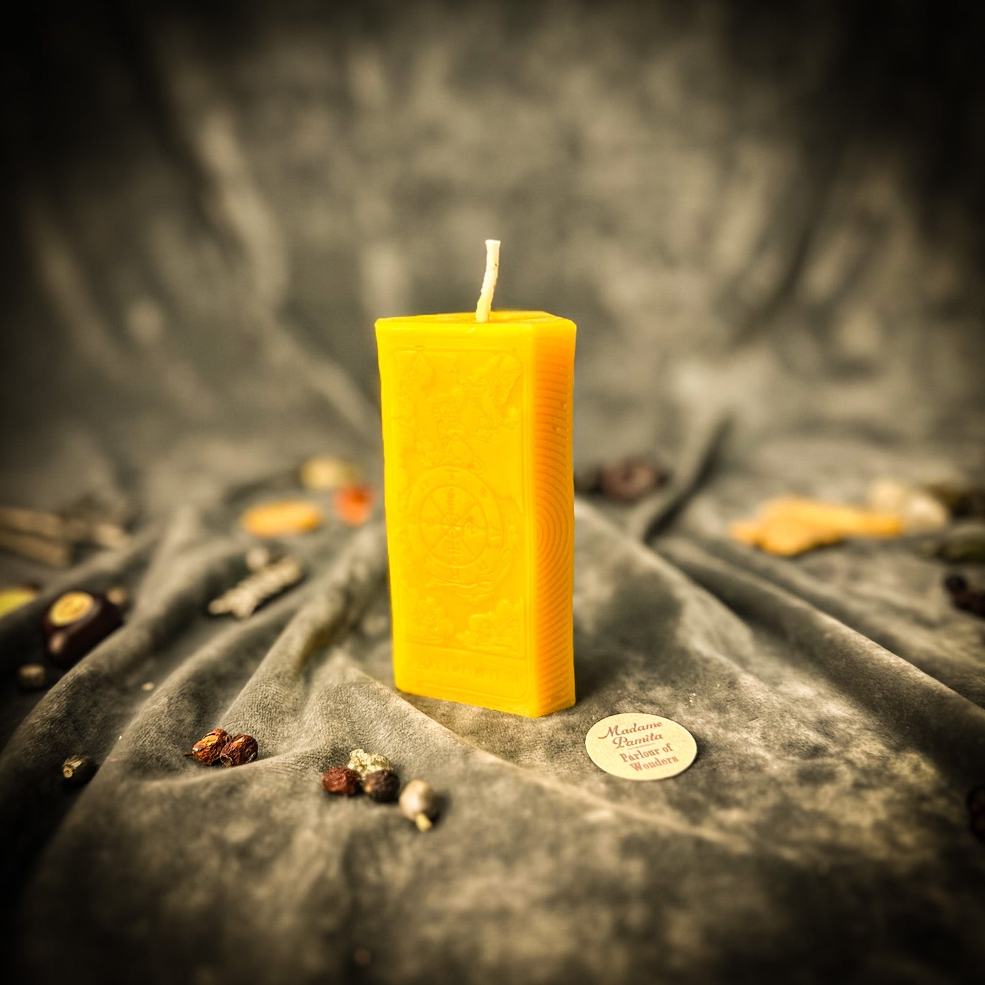 Yellow candle on a textured gray surface with a blurred background