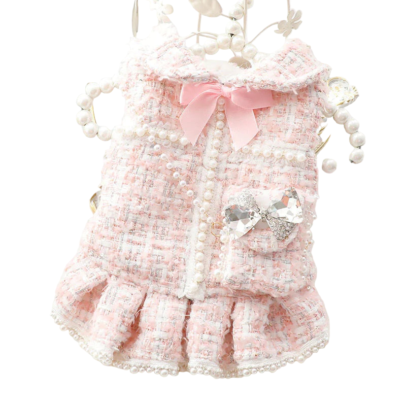 Pink pet dress with bow and pearl details on a decorative background