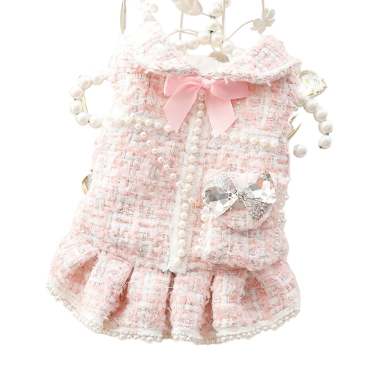 Pink pet dress with bow and pearl details on a decorative background