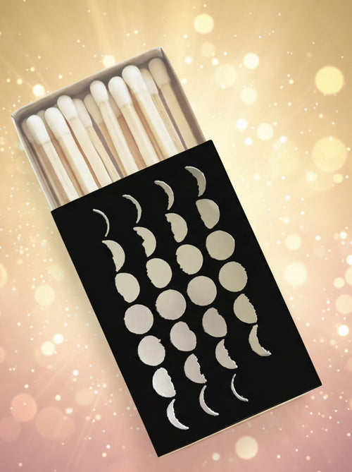 Matchbox with white matches and black box featuring moon phases on a white background