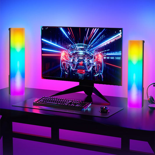 Gaming setup with monitor, keyboard, and RGB lights on a desk.