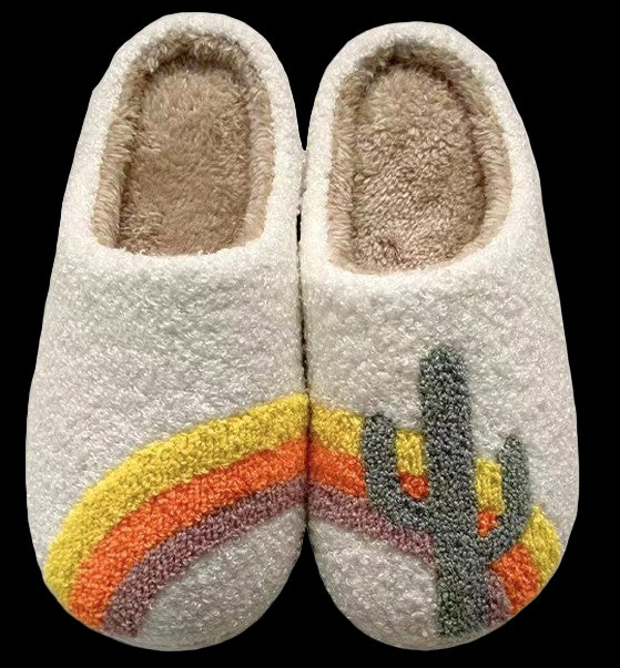 Pair of fuzzy slippers with a cactus design on a white background