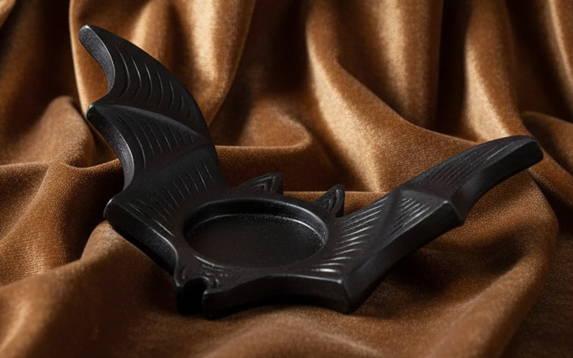 Black bat-shaped candle holder on a white background