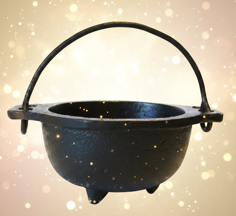 Black cast iron cauldron with handle on a white background