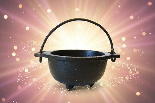 Black cast iron cauldron with handle on a white background