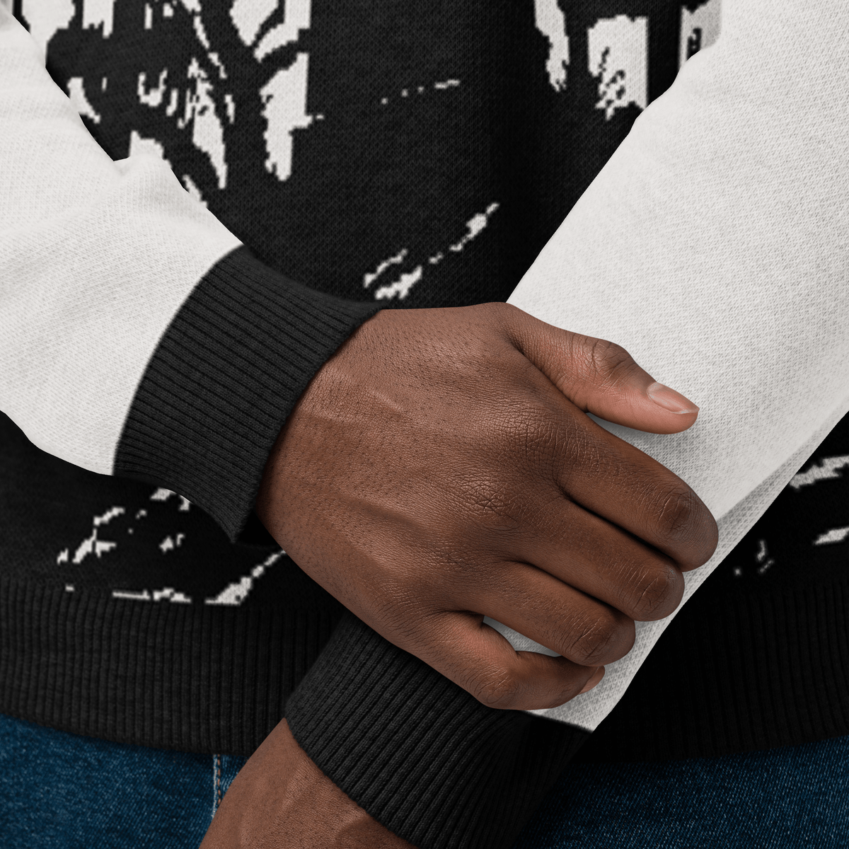 Close-up of a person wearing a black and white patterned sweater with a focus on the sleeve and hand.