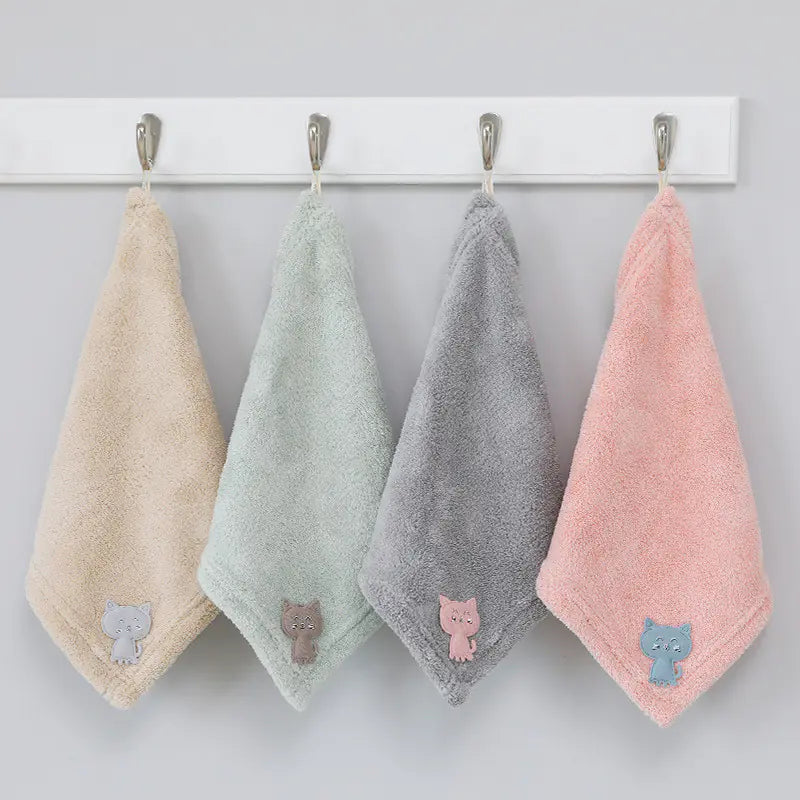 Four colorful towels with cat appliqués hanging on a rack against a white background.